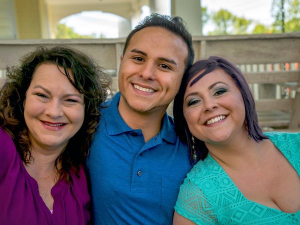 Two women and a man smiling