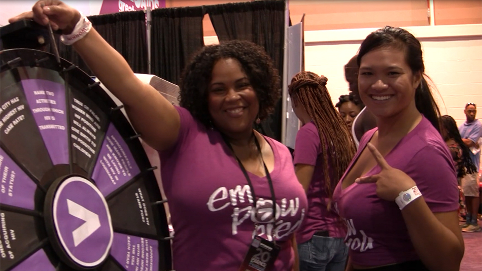 Volunteers Trina and Amy wearing magenta Empowered shirts at Greater Than AIDS event