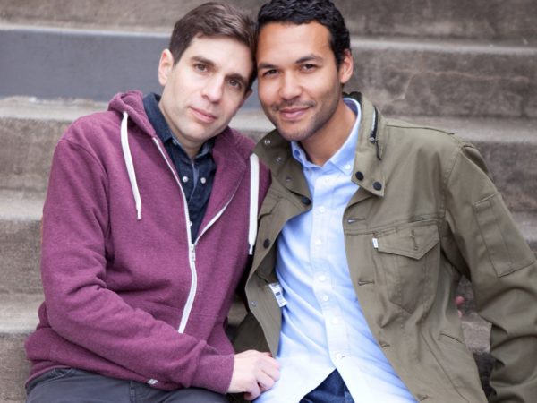 Two men smiling with their arms around each other