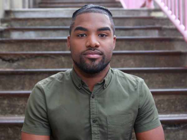 Man sitting on stairs looking at camera