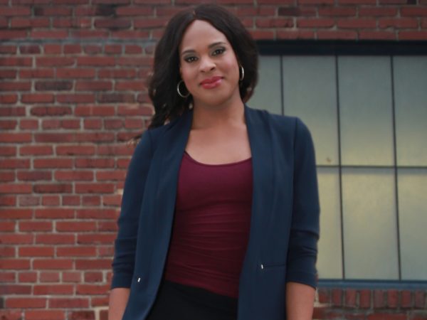 Woman smiling against brick wall