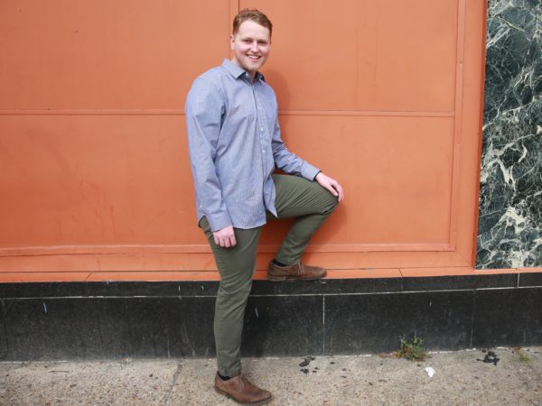 Man smiling with his leg on a ledge