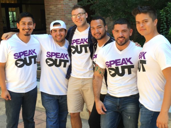 Group of people standing wearing Speak Out white t-shirts