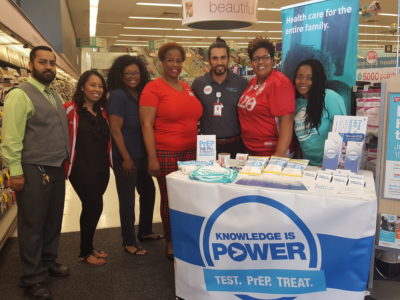People standing at HIV information table at Walgreens