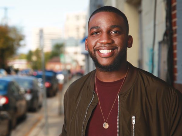 Man looking at camera smiling outside