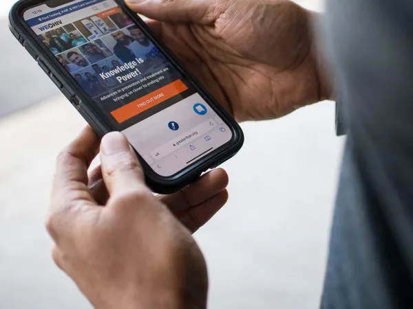 Hands holding phone with a website on the screen